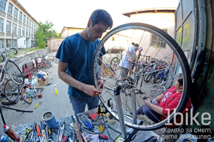 Доброволец поправя колело за смет